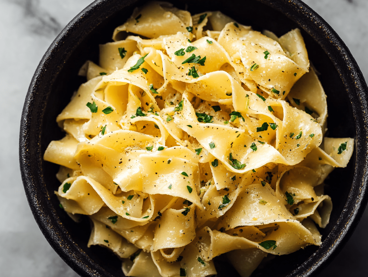 Garlic Butter Noodles That Taste Rich, Cozy, and Homemade 4 Garlic butter noodles in black bowl with parsley and pepper